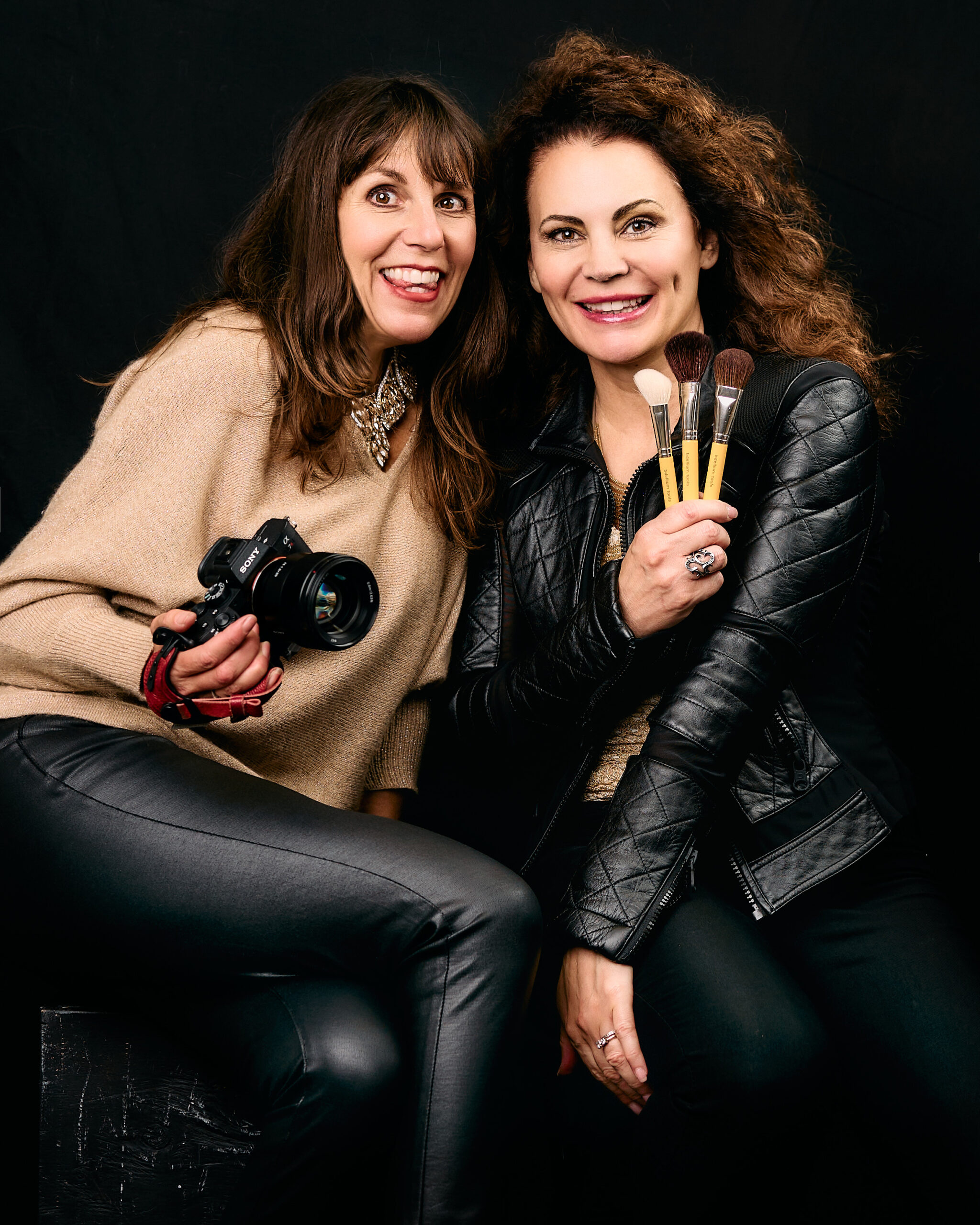 Dena and Tanya posing with camera and makeup brushes
